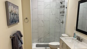Une salle de bain moderne équipée d’une douche, de toilettes et d’un lavabo.