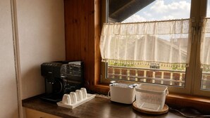 Eine Küchenarbeitsplatte mit Kaffeemaschine, einer weißen Tassehalterung und einem Korb.