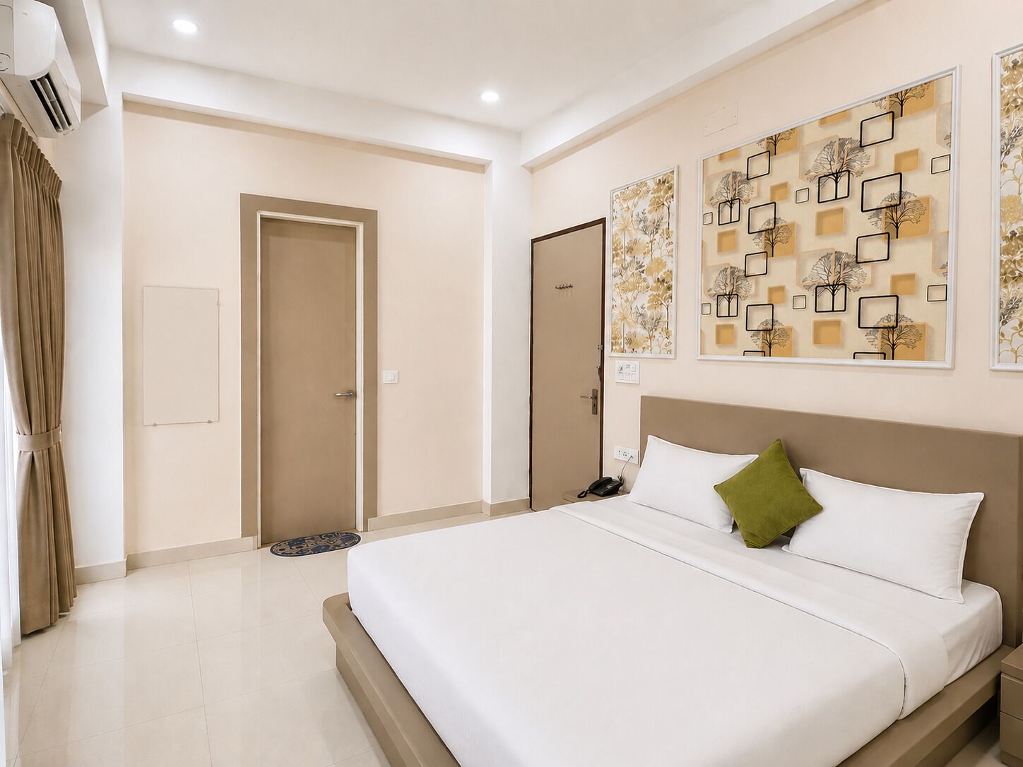 A hotel room with a large bed, a bedside table, a wall-mounted phone, and a door with a curtain.