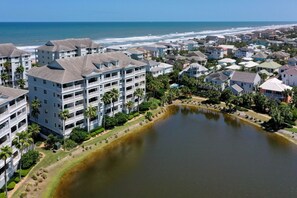 A coastal residential area with multi-story buildings, a small lake, and a beach in the background. - Beautiful sunsets from 3rd Floor condo #934 (Palm Coast)