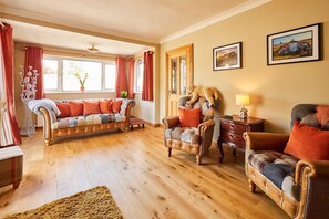 A cozy living room with a sofa, armchairs, and a wooden floor. - Host Stay - The Mews (Morpeth)