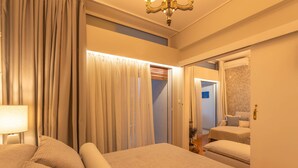 Ein Hotelzimmer mit Bett, Nachttisch, Lampe, Kleiderschrank und Spiegel.