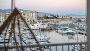 Ein Yachthafen mit zahlreichen Booten, einer Uferpromenade und Wohnhäusern im Hintergrund.