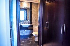 Ein Badezimmer mit Waschbecken, Toilette und dunklen Holzschränken.