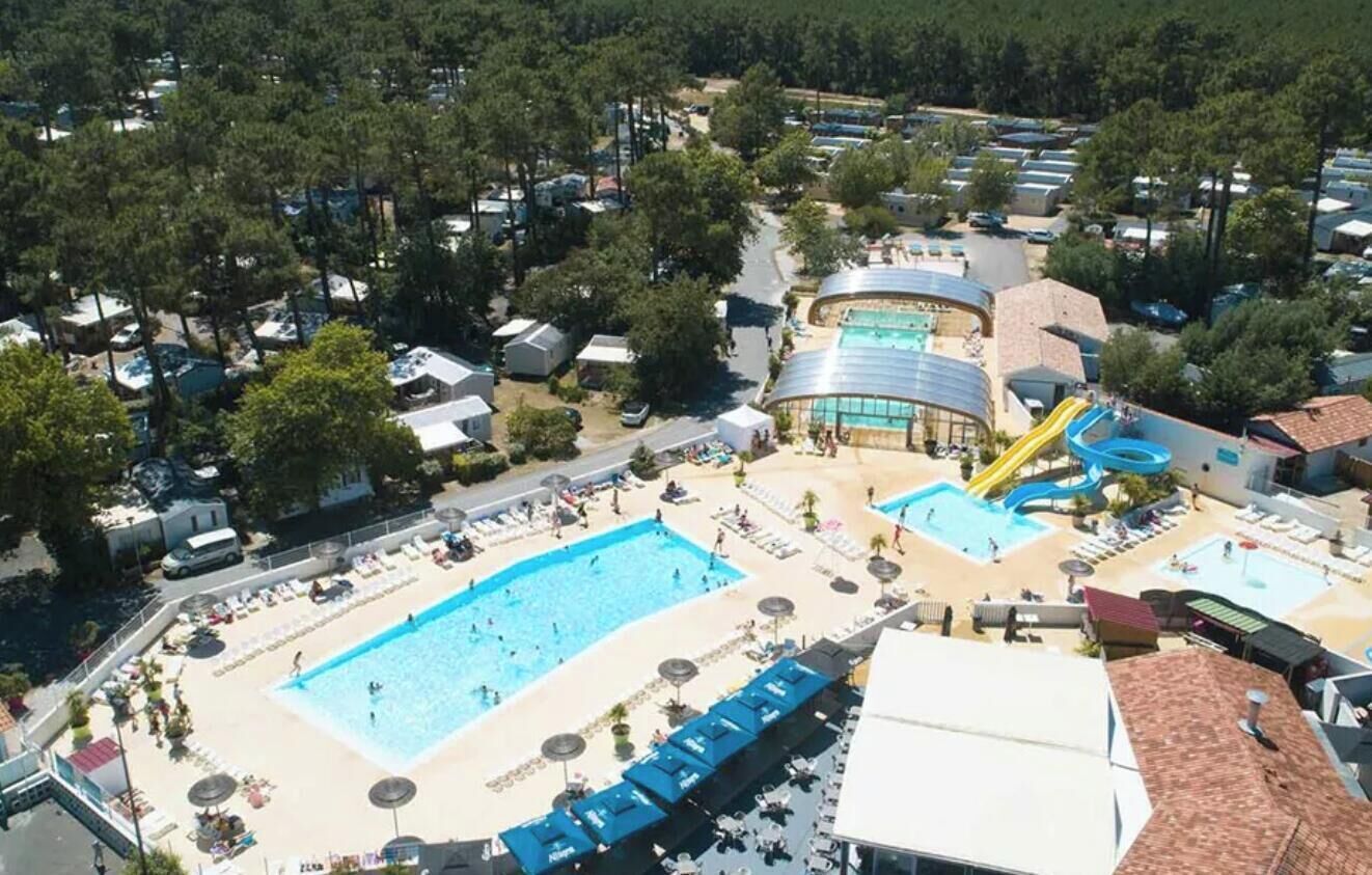 Eine Vogelperspektive eines Resorts mit mehreren Schwimmbecken, einem Wasserpark und verschiedenen Unterkünften.