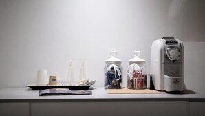 Eine Küchenarbeitsplatte mit Kaffeemaschine, Gläsern und einer Tablett mit Gegenständen.