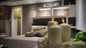 Ein Schlafzimmer mit einem Bett, einem Nachttisch, einem Regal mit Dekoration und einer Tür.