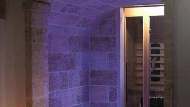 Ein Zimmer mit Stehwänden, einem blau beleuchteten Pool und einer Treppe, die zu einer Tür führt.