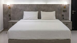 A modern bedroom with a large bed, two bedside tables, and wall-mounted lighting. - Hamsun Clifton Apartment 3 Bedroom (Karachi)