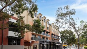 A multi-story building with balconies, a brick facade, and a clear sky. - Your East Perth Haven awaits! Walk to Optus Stadium, Crown Perth and the CBD. Enjoy iconic Swan River walks, vibrant Claisebrook Cove for coffee and dining and super easy city access with the free CAT bus (20mins). (East Perth)