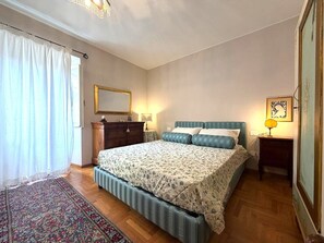 A bedroom with a bed, a dresser, a mirror, a rug, and a nightstand with a lamp. - Beautiful apartment for 6 guests with A/C, WIFI and panoramic view (Cortona)