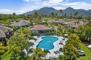 A resort with a swimming pool, multiple buildings, and a mountainous backdrop. - Newly Remodeled & Furnished, Spacious 2BR Condo (Princeville)