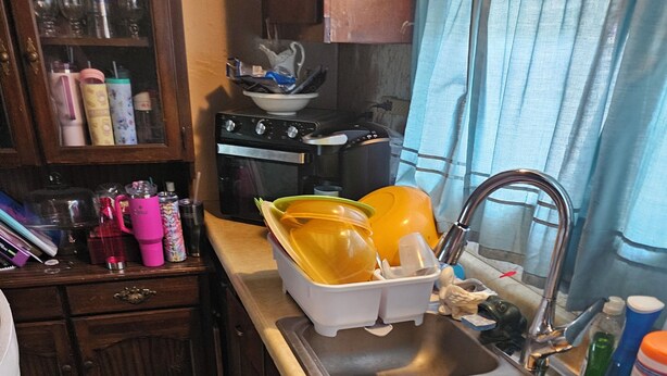 A kitchen with a sink, stove, and various kitchen items. - Charming house in soothing Beckley with cool AC breeze (Beckley)