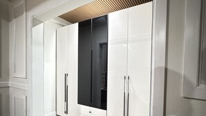 Un couloir avec un plafond en bois, des murs blancs et un sol carrelé.