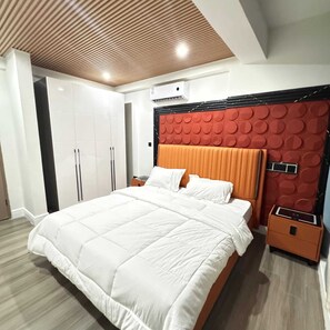 Un dormitorio moderno con una cama grande, un armario y un diseño de cabecera circular único.