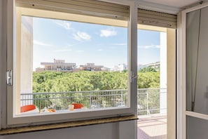 Ein Balkon mit Blick auf Gebäude und Grünflächen.