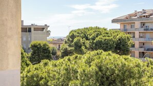A residential area with multi-story buildings, a large tree in the foreground, and a clear sky. - Lovely apartment for 4 people with WIFI, A/C, TV, balcony and panoramic view (Lido Di Fermo)