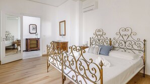 A bedroom with a metal bed frame, a wooden dresser, a mirror, and a picture on the wall. - Lovely apartment for 4 people with WIFI, A/C, TV, balcony and panoramic view (Lido Di Fermo)