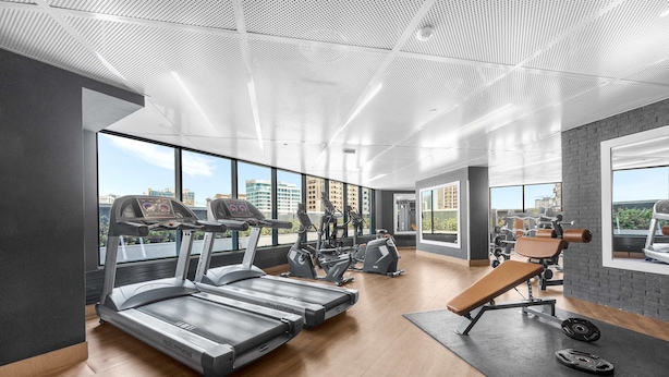 A modern gym with treadmills, weight machines, and a bench. - Free Housekeeping Visits During Your Stay - Stayshort - Studio in Dubai Land That Sleeps 3 Close to Global Village (Dubai)