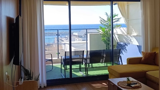 A room with a large sliding glass door leading to a balcony with a view of the sea. - Luxury Stunning 2BR Marina Apt with Sea View (Ashkelon)