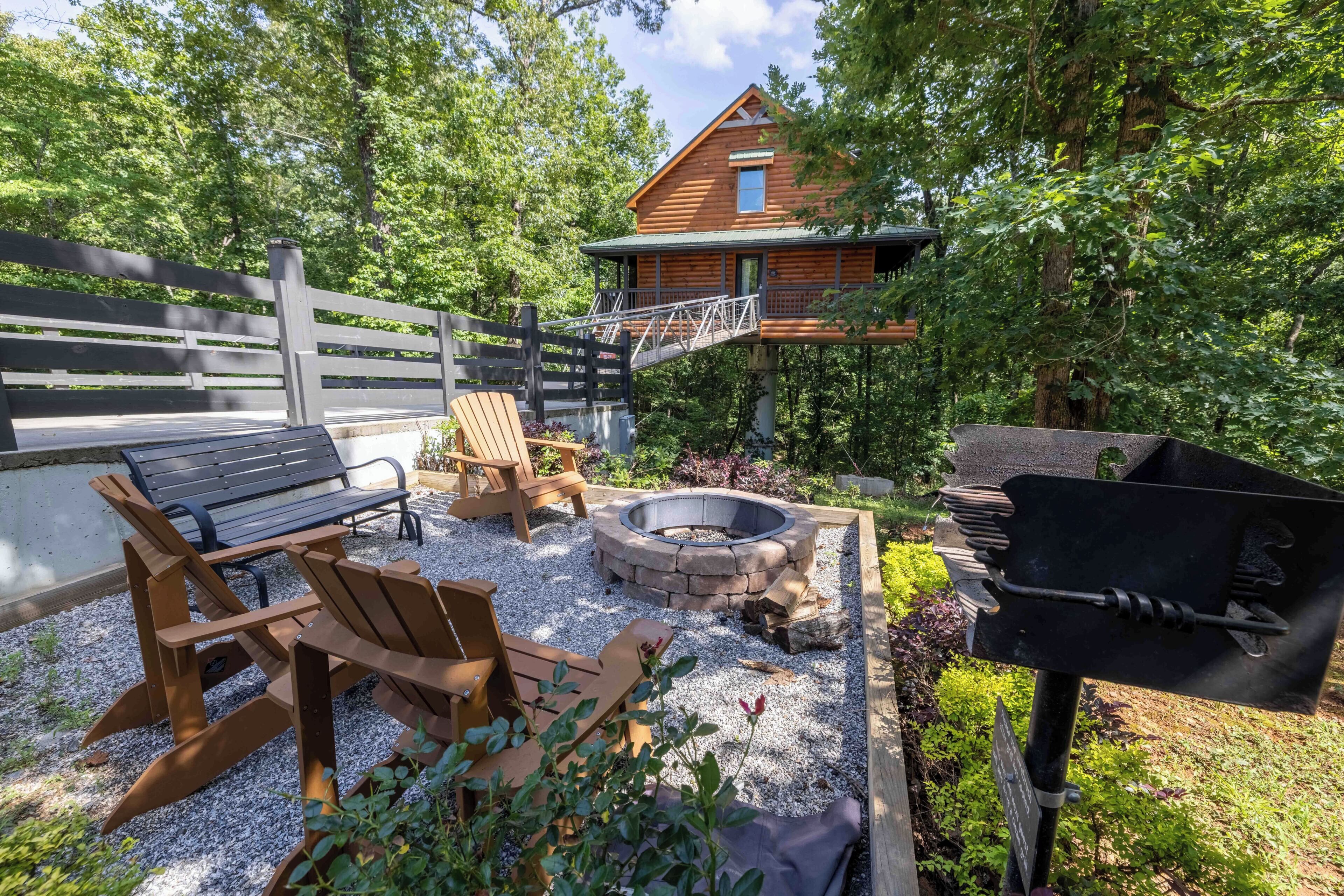 A wooden deck with outdoor furniture, a fire pit, and a grill area.