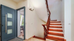 Eine Treppe mit Holzdielen und einer Glastür, die zu einem Außenbereich führt.