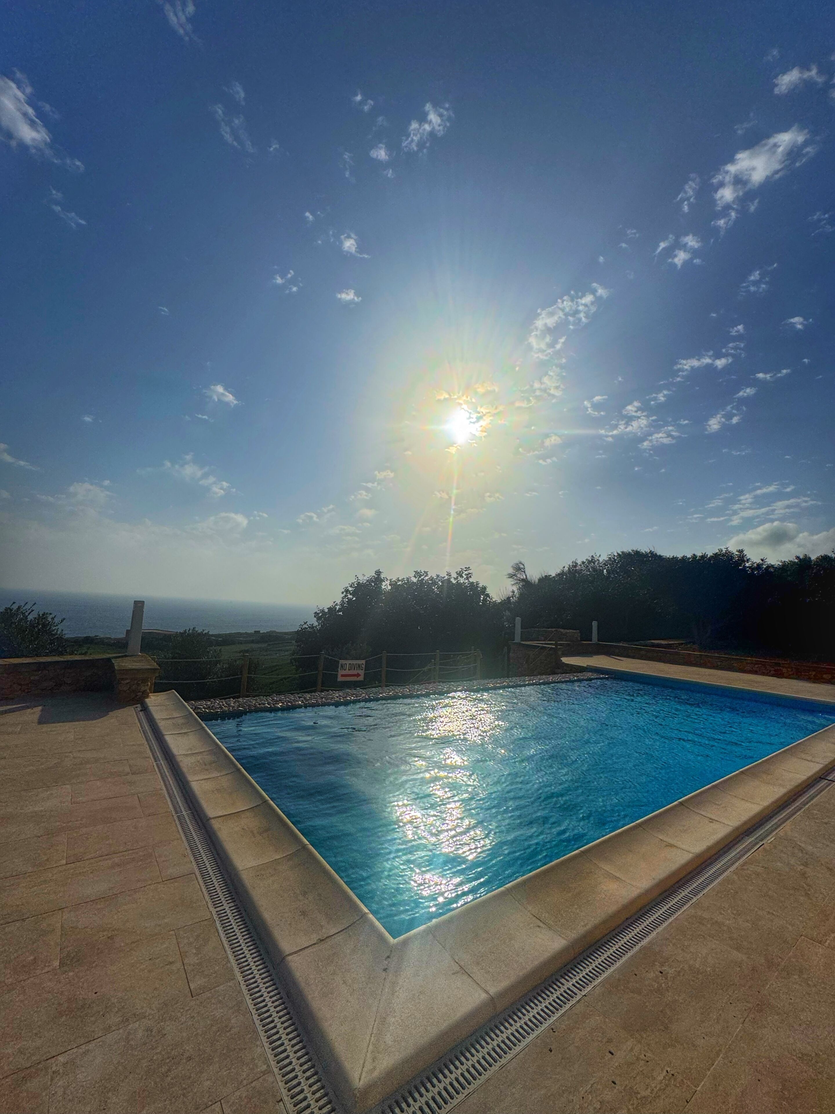 Piscina con vista sull'oceano e cartello con scritta 'No Diving'.