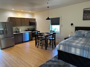 Um espaço compacto com cozinha compacta, área de refeições e cama.