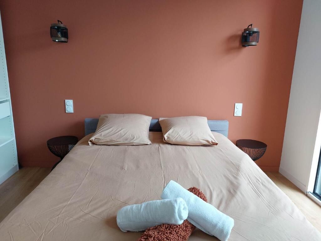 Una camera da letto con un letto, due cuscini, due lampade a parete e una finestra.