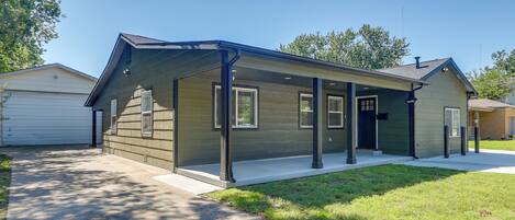 A single-story house with a covered porch, a garage, and a well-maintained lawn.