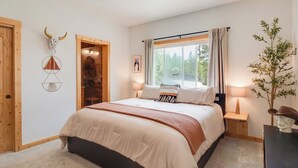 A bedroom with a bed, bedside tables, a ceiling fan, a window with curtains, and a wall-mounted decoration. - Rocky Mtn Hideaway w/ Hot Tub & Panoramic Views (Fairplay)