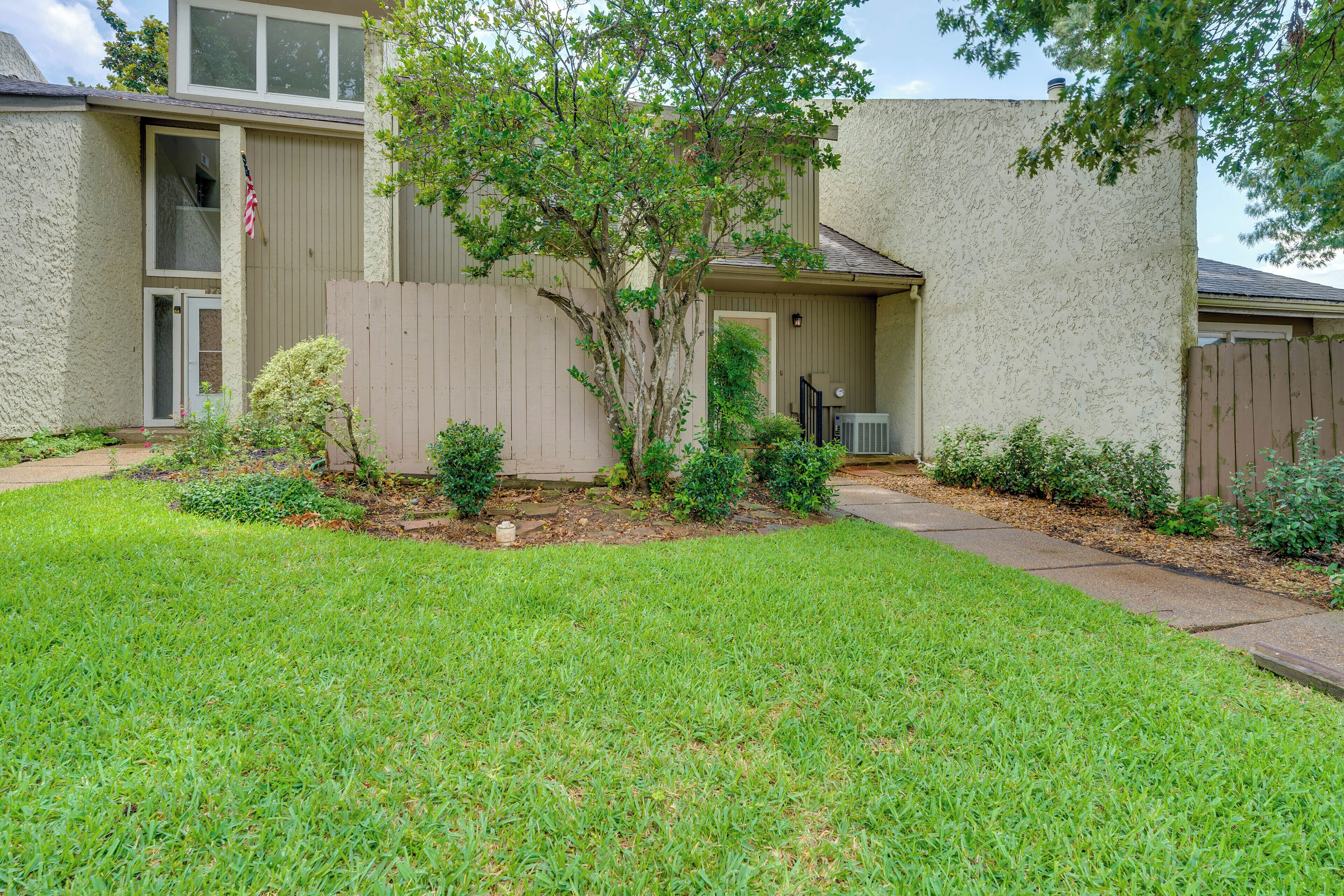 A residential building with a front yard, a small tree, and a mailbox.