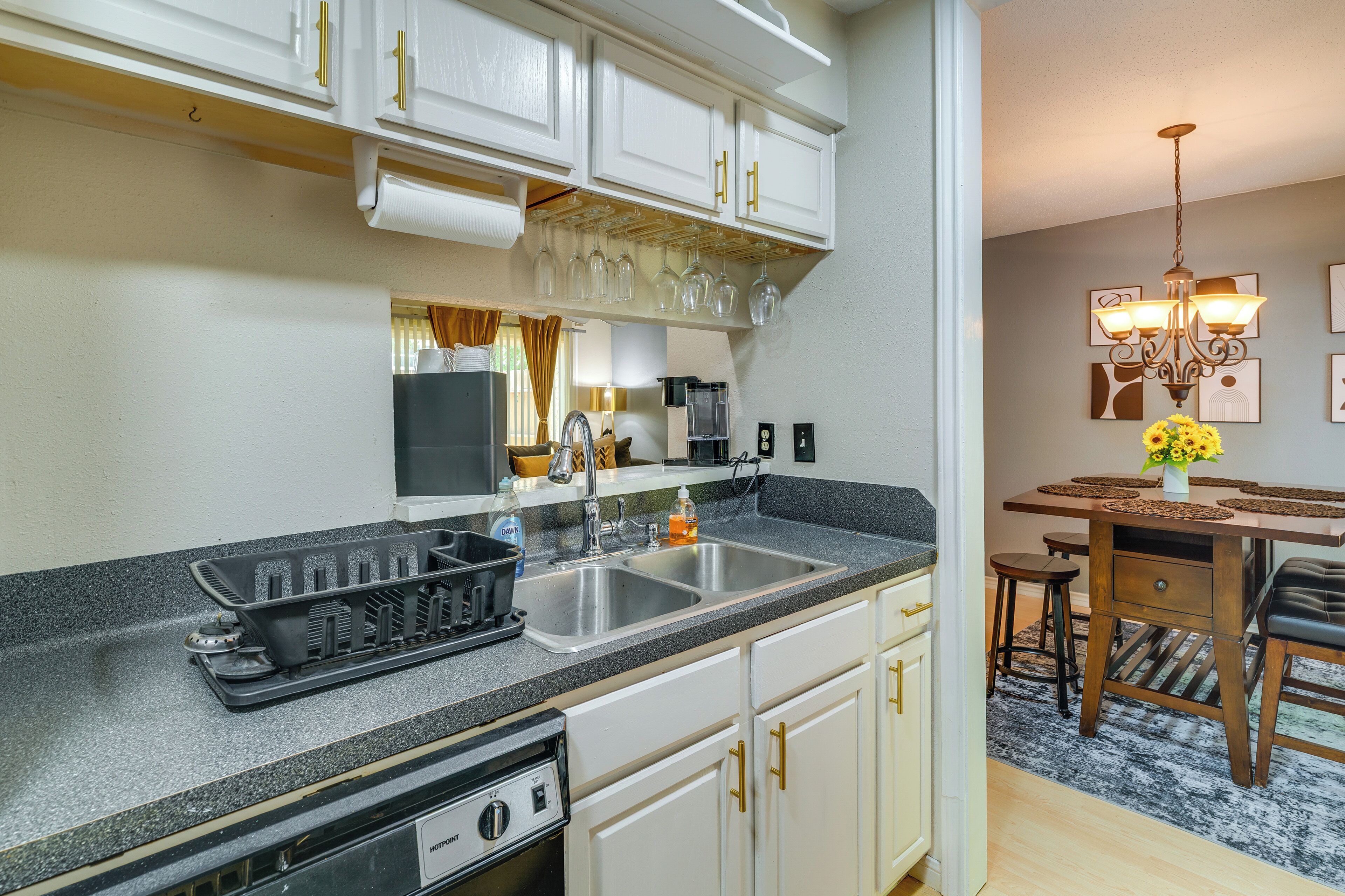 A kitchen with white cabinets, a granite countertop, a stove, and a sink.
