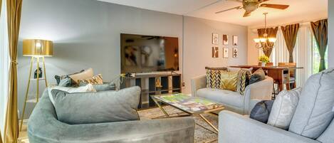 A living room with two sofas, a coffee table, a TV, and a ceiling fan.