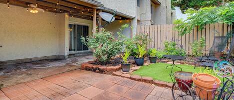 A patio with potted plants, a bicycle, and outdoor furniture.