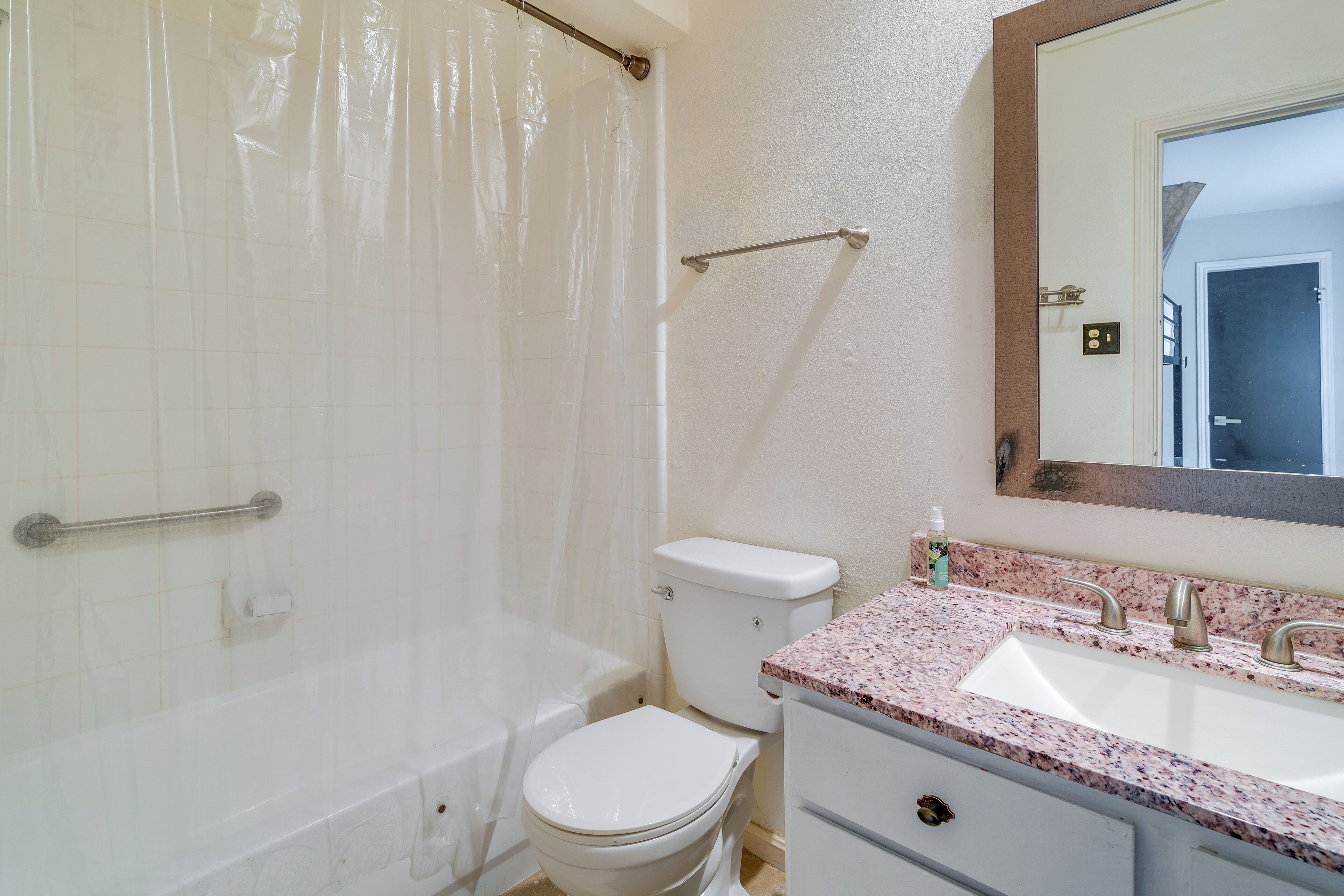 Baño con bañera, inodoro, lavabo y espejo.