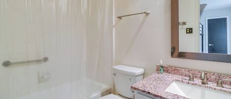 Baño con bañera, inodoro, lavabo y espejo.