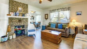 A living room with a stone fireplace, a ceiling fan, a sofa, and a coffee table. - Balcony w/ Stunning View! Lake Junaluska Retreat (Lake Junaluska)