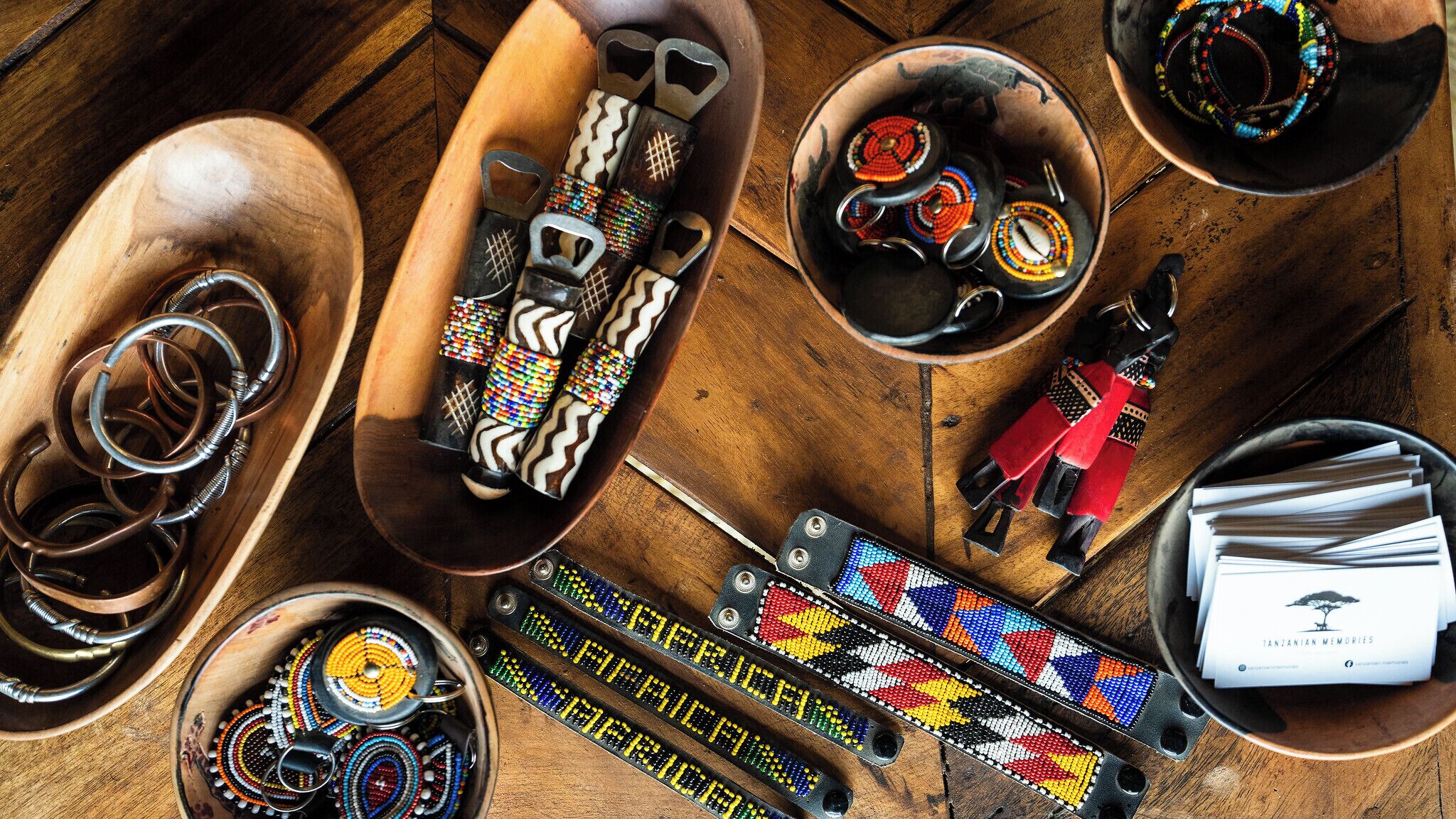 Une variété de bijoux et d’accessoires ornés de perles, exposés sur des supports en bois.