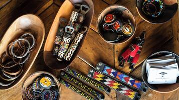 Une variété de bijoux et d’accessoires ornés de perles, exposés sur des supports en bois.