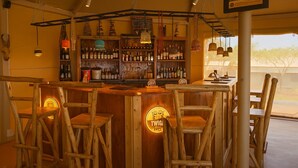 Un rústico espacio de bar con muebles de madera y una variedad de botellas en estantes.