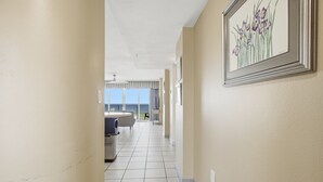 Ein Hotelkorridor mit Essbereich, Deckenventilator und einem gerahmten Blumenbild an der Wand.