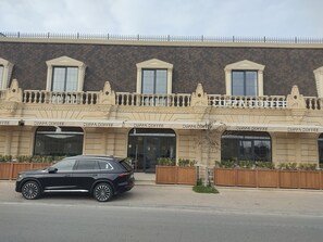 Ein Gebäude mit mehreren Fenstern und einem schwarzen Auto davor.