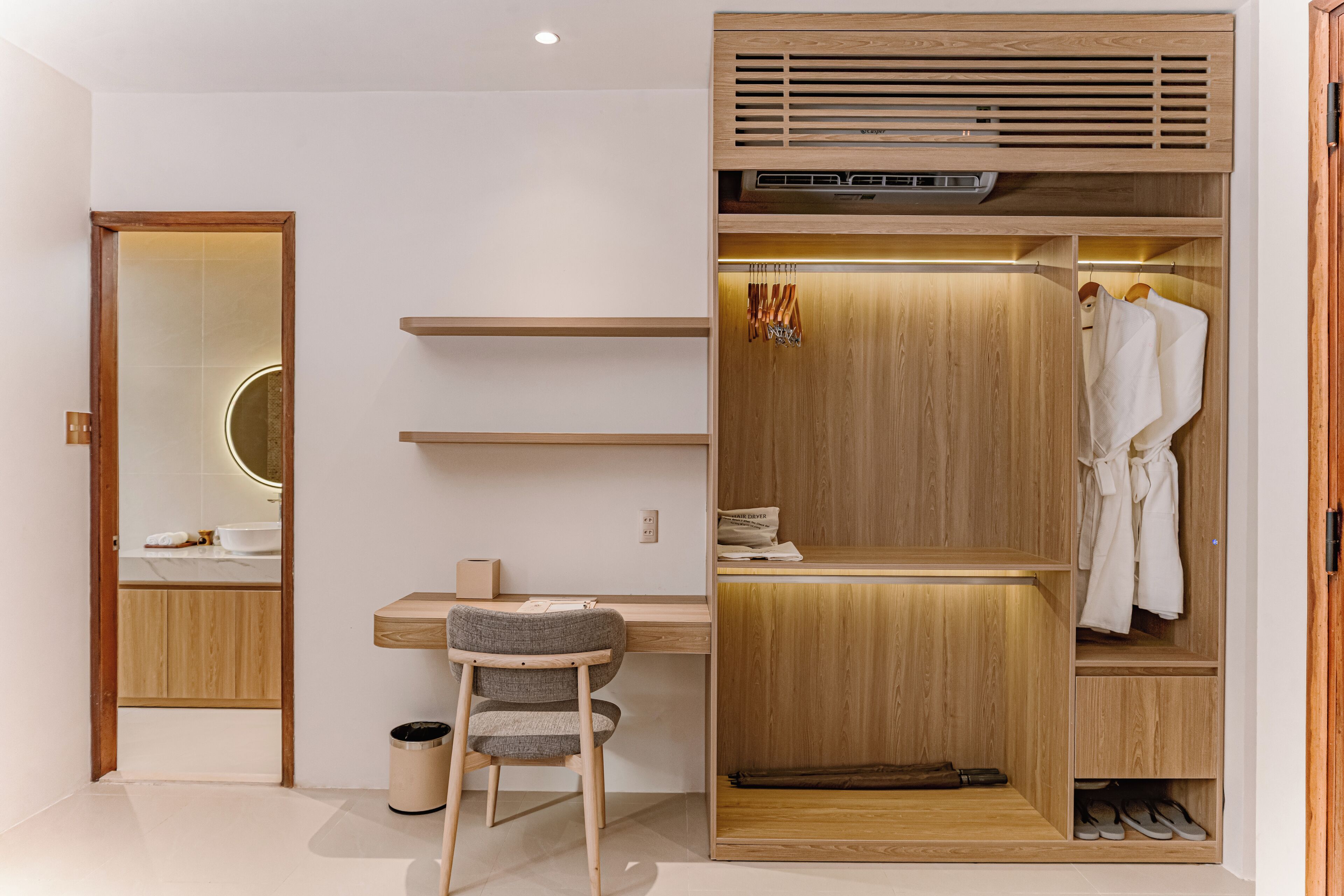 Une chambre moderne avec un bureau en bois, une chaise, une armoire et un miroir.
