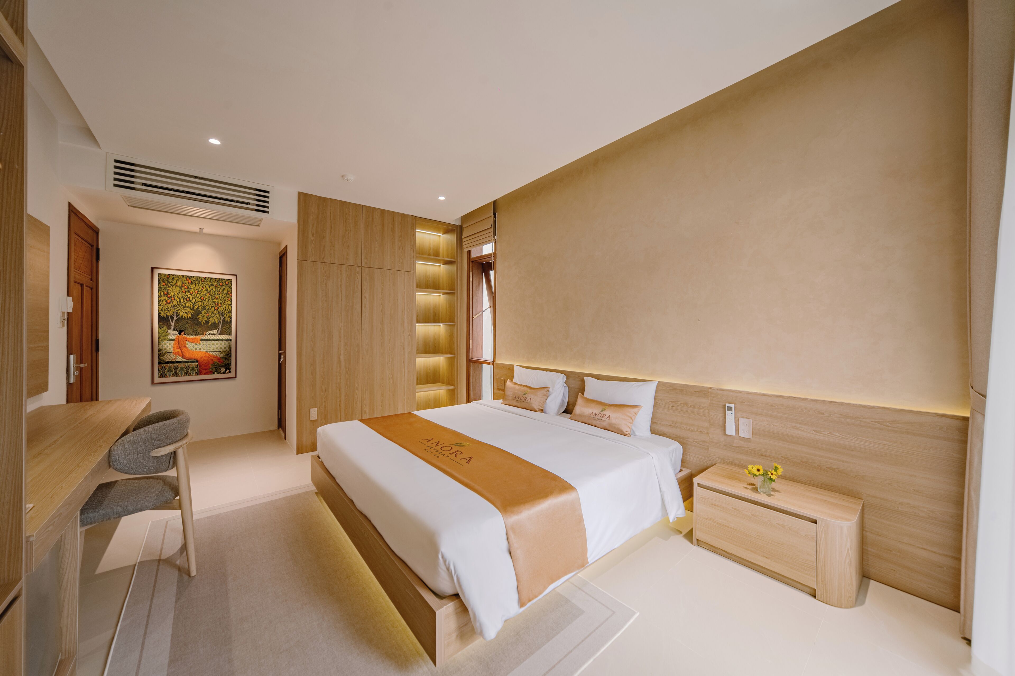 A modern hotel room with a large bed, a desk, and a chair.