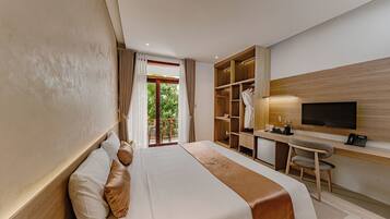 A hotel room with a bed, a desk, a TV, and a wardrobe.