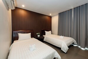 A hotel room with two beds, wooden paneling on the wall, a nightstand with a lamp, and a window with curtains. - High Pearl Boutique (Siem Reap)