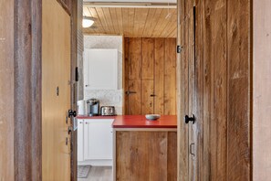 A kitchen with wooden cabinets, a red countertop, and white appliances. - City Explorer Basecamp Buffalo 1 Bedroom Duplex (Buffalo)
