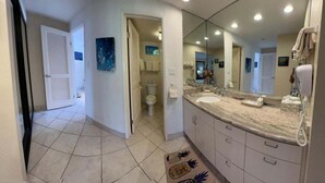 A bathroom with a large mirror, a sink, and a toilet. - Point Oceanfront 2BR Loft with Views - Unit C05 (Lahaina)