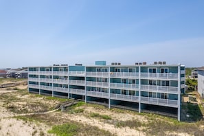 Ein mehrstöckiges Gebäude mit Balkonen in der Nähe eines Sandstrandes.